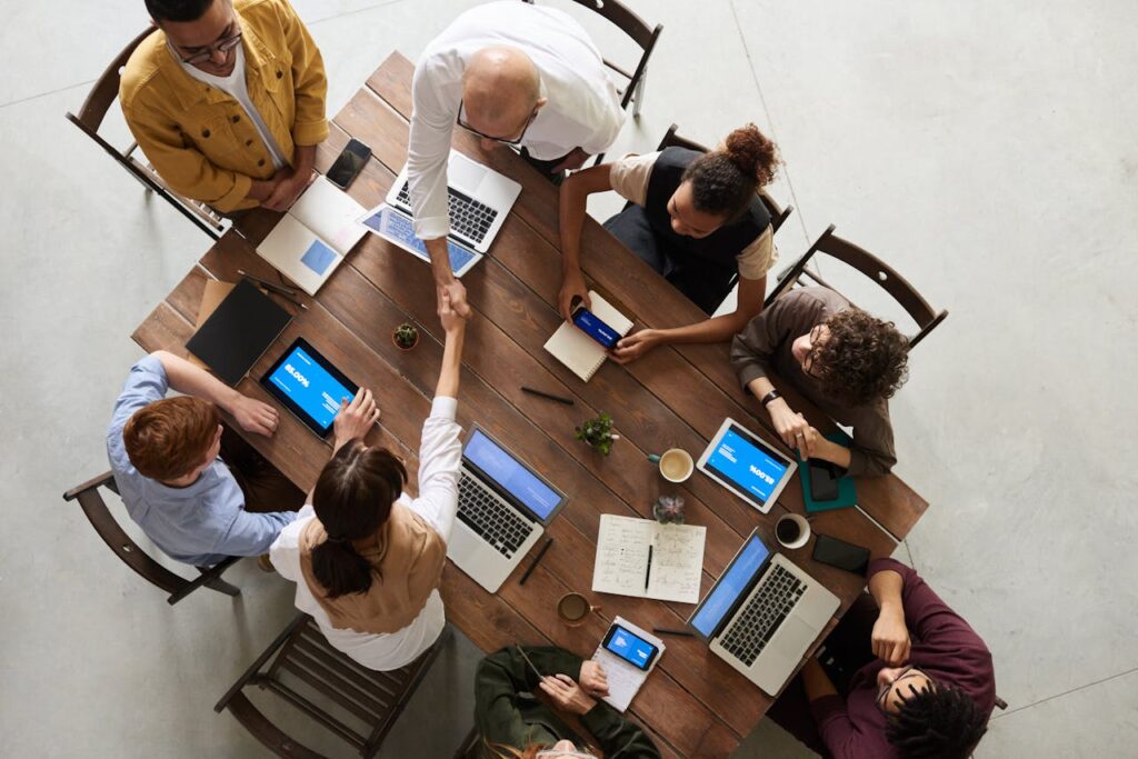 People with phones and computers sitting around a desk  .jpg